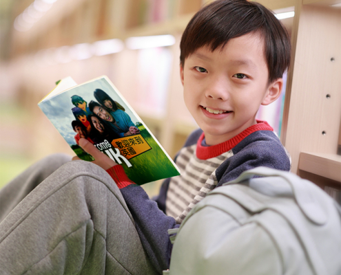 Young boy reading The Welcome to the UK book